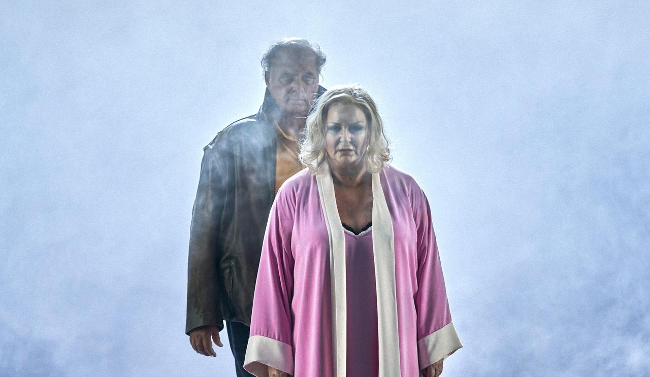 Iréne Theorin als Brünnhilde und Albert Dohmen als Hagen stehen hintereinander im Nebel auf der Bühne. Iréne Theorin als Brünnhilde und Albert Dohmen als Hagen stehen hintereinander im Nebel auf der Bühne.