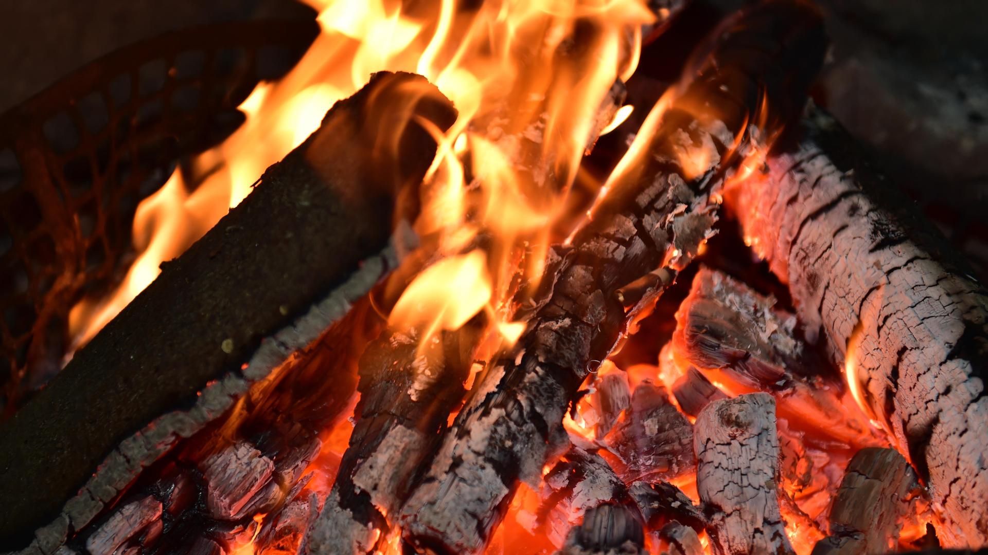 Halb abgebrannte Holzscheite liegen im Feuer. Halb abgebrannte Holzscheite liegen im Feuer.