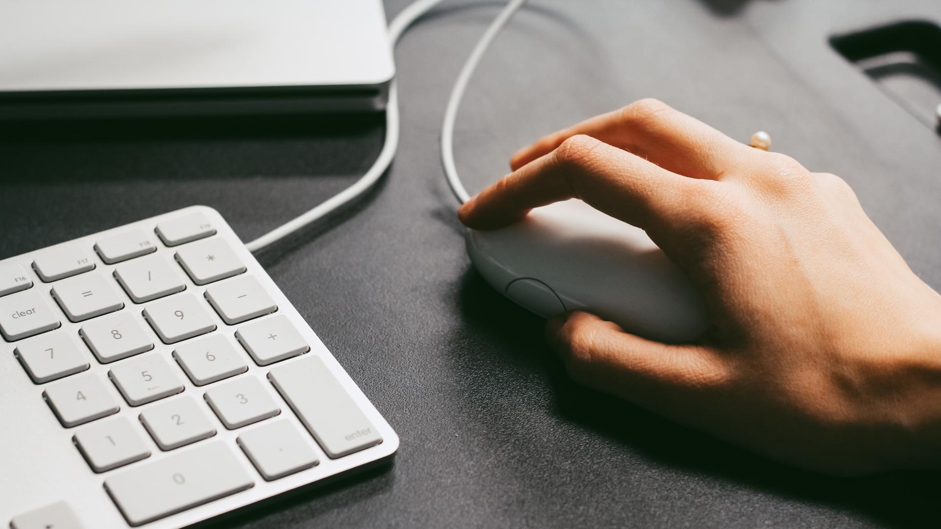 Eine Hand hält eine Computermaus Eine Hand hält eine Computermaus