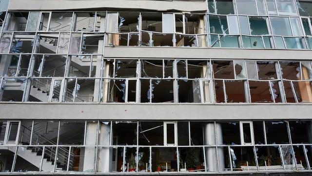 Blick auf ein Sportgebäude in Kiew, dessen Außenfassade durch russische Raketenangriffe zerstört wurde