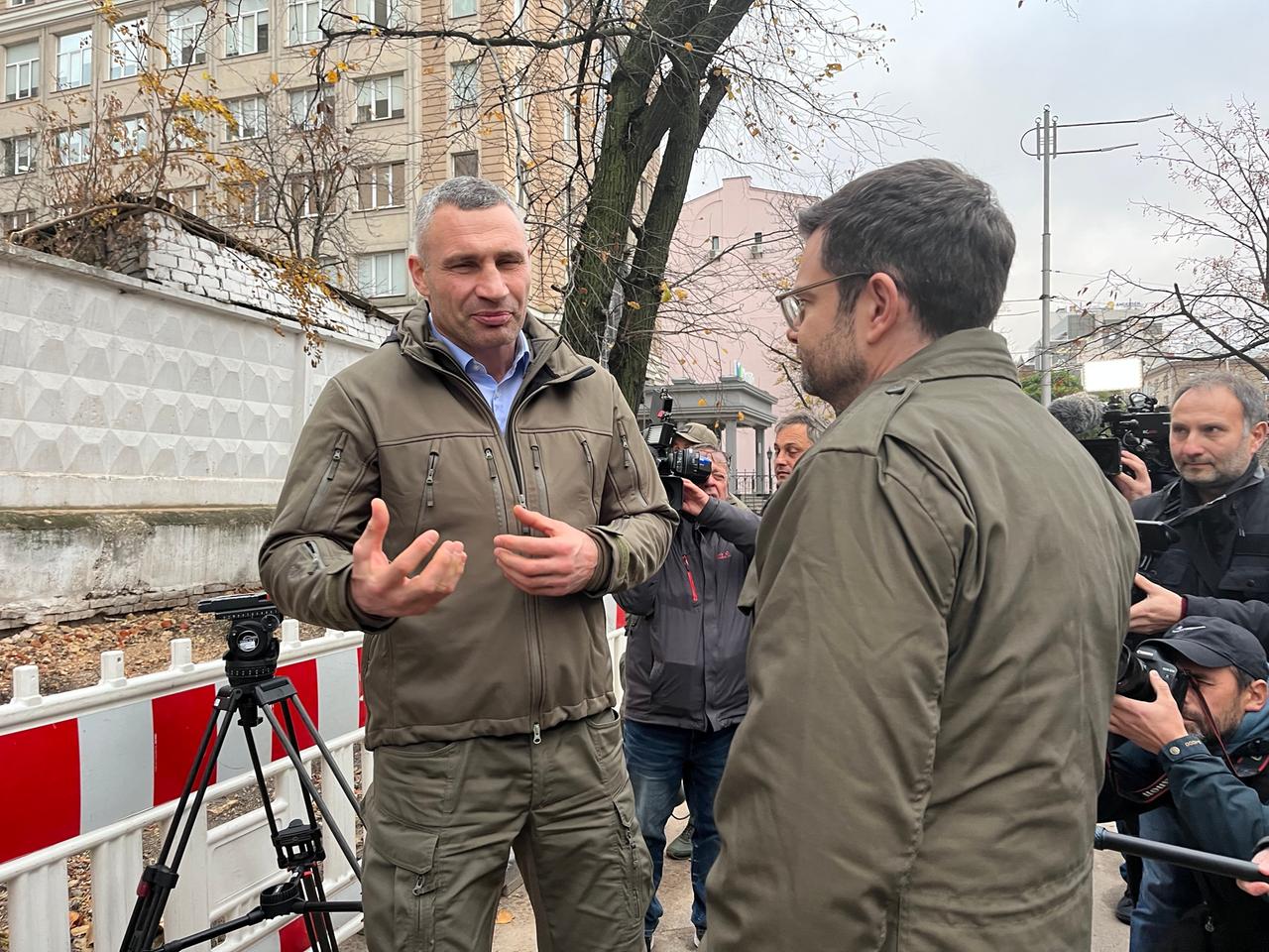 Marco Buschmann (FDP), Bundesminister der Justiz, spricht mit Kiews Bürgermeister Vitali Klitschko vor einem im Oktober 2022 durch einen Drohnenangriff zerstörten Haus in der ukrainischen Hauptstadt. Sie sind von Journalisten umgeben.