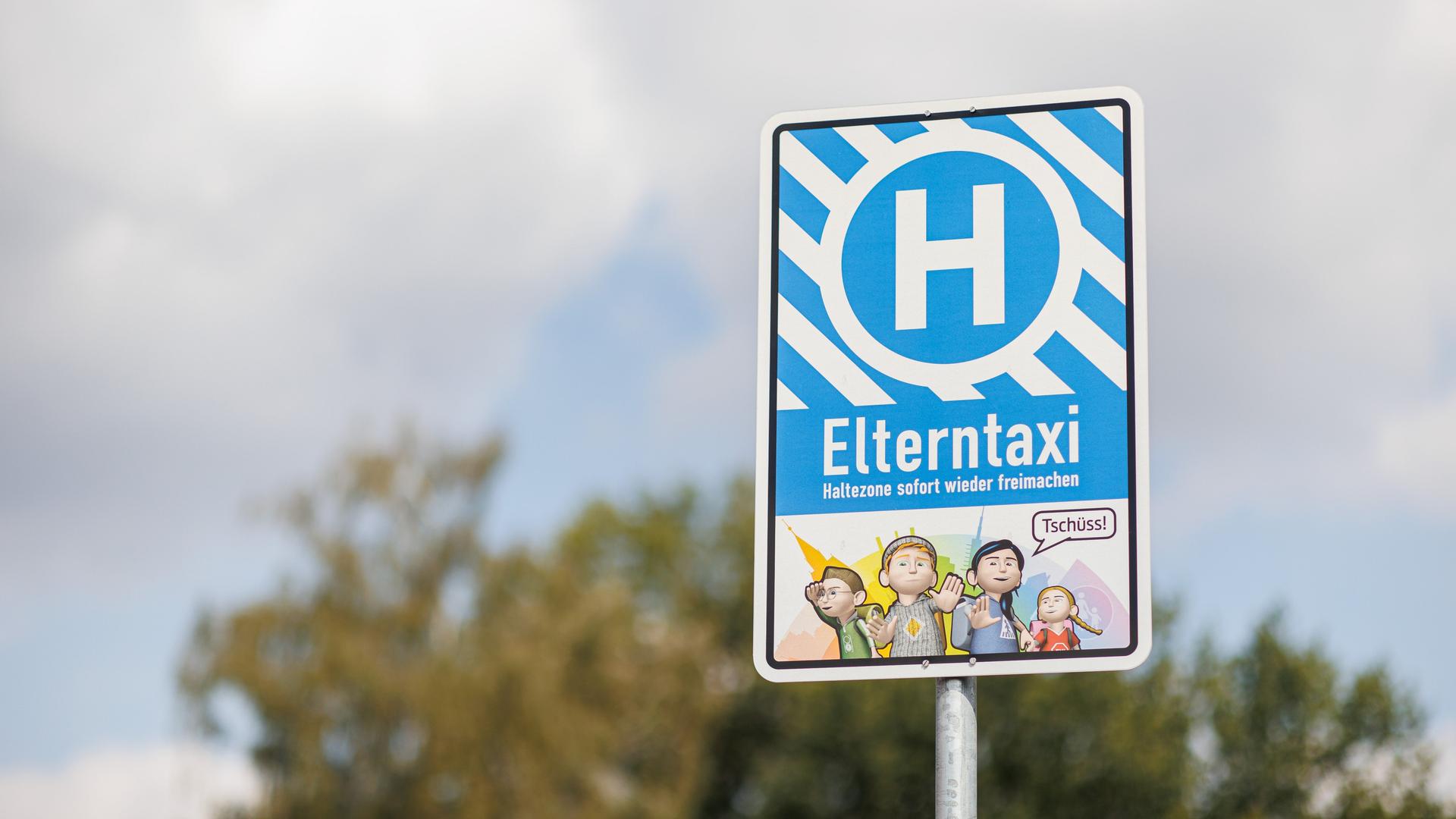 Ein Schild mit der Aufschrift "Elterntaxi" steht an einer Straße Ein Schild mit der Aufschrift "Elterntaxi" steht an einer Straße