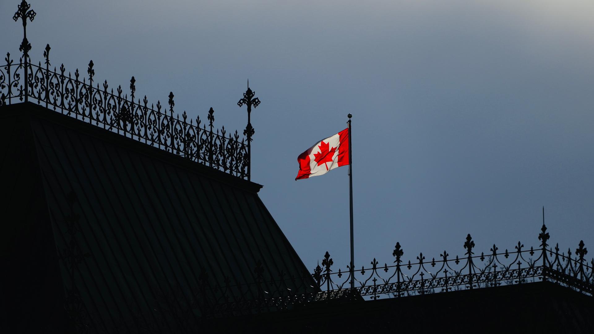 Zu sehen ist die kanadische Flagge auf einem Hausdach