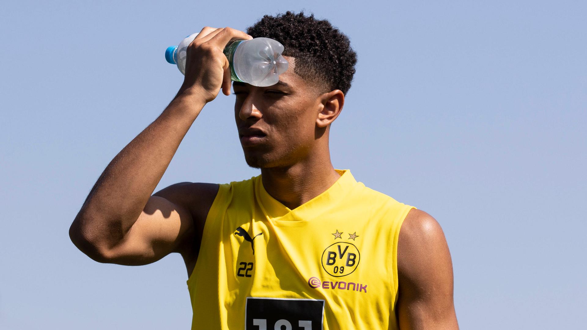 Fußballer Jude Bellingham von Borussia Dortmund kühlt seine Stirn mit einer Wasserflasche. Fußballer Jude Bellingham von Borussia Dortmund kühlt seine Stirn mit einer Wasserflasche.