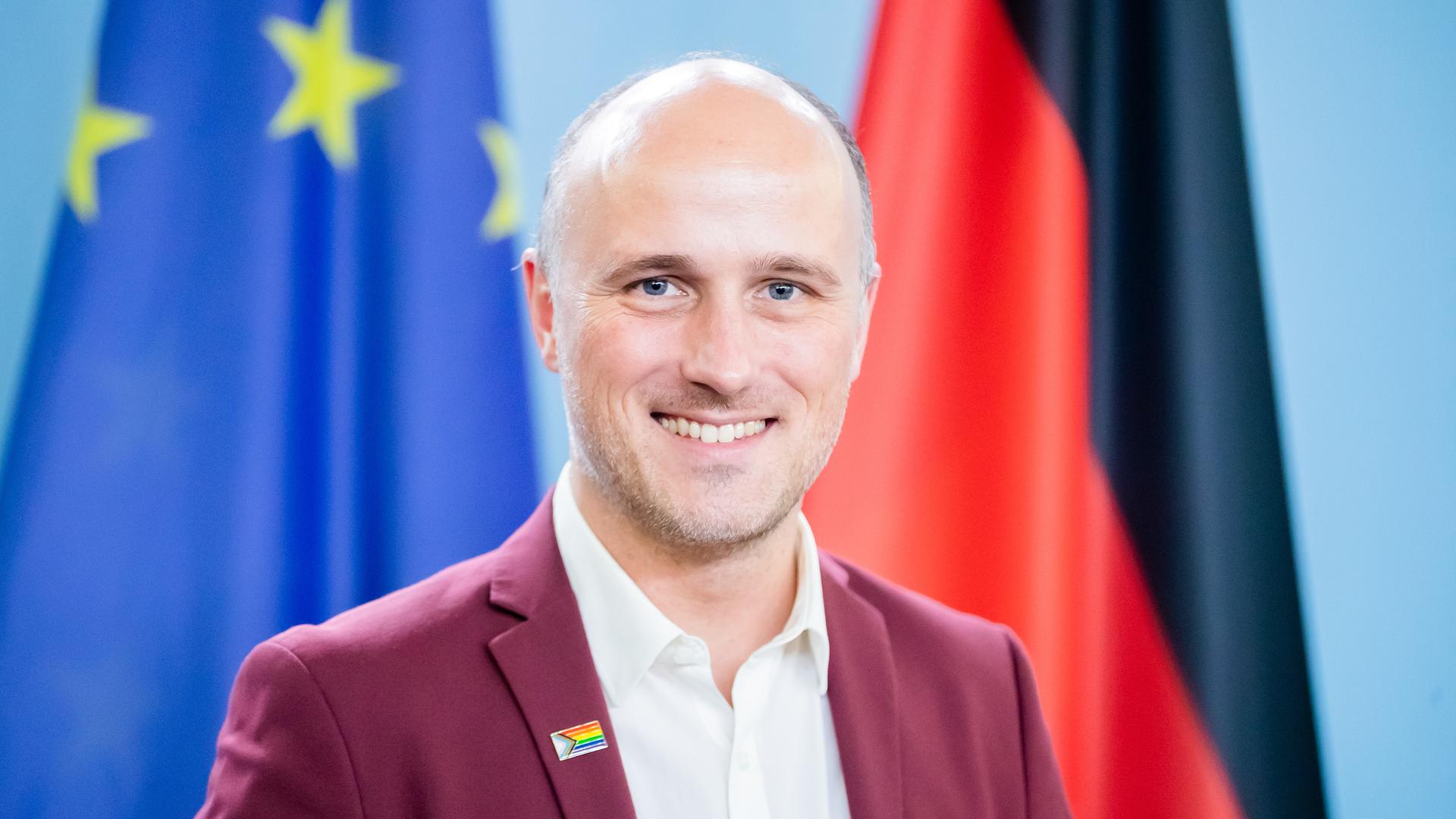 Sven Lehmann steht vor einer europäischen und einer deutschen Fahne Sven Lehmann steht vor einer europäischen und einer deutschen Fahne