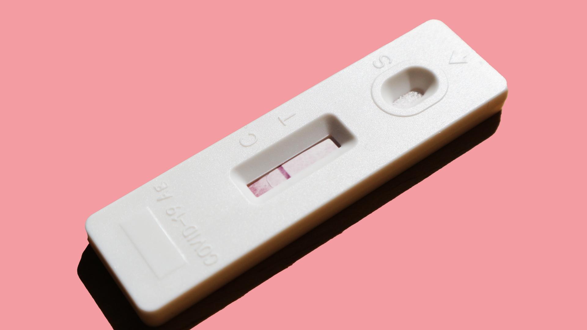 Ein Covid-19-Selbsttest auf rosafarbenem Untergrund mit einer roten Linie im Bereich C. Ein Covid-19-Selbsttest auf rosafarbenem Untergrund mit einer roten Linie im Bereich C.