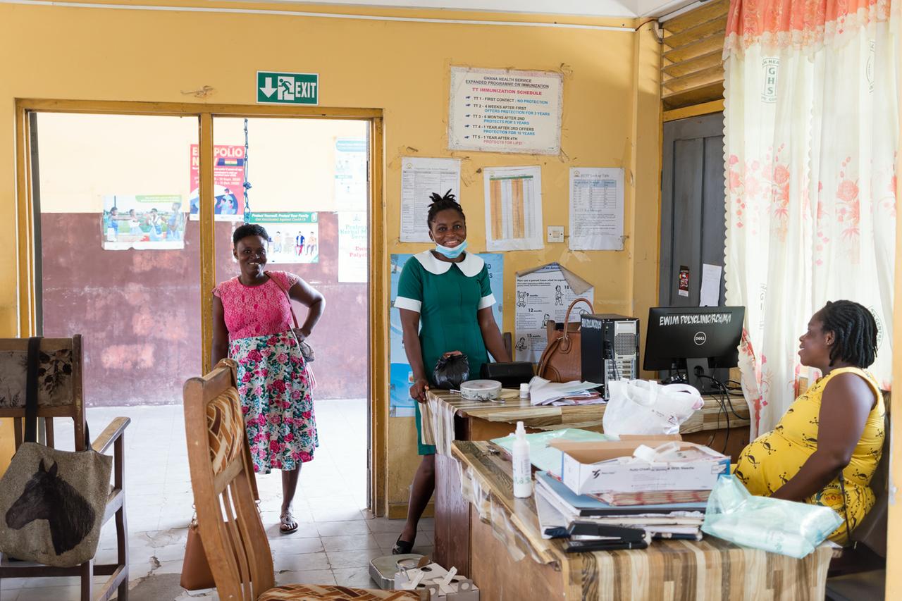 Eine Mitarbeiterin am Schreibtisch und Besucherinnen in der Ewim-Poliklinik in Capecoast, Ghana Eine Mitarbeiterin am Schreibtisch und Besucherinnen in der Ewim-Poliklinik in Capecoast, Ghana