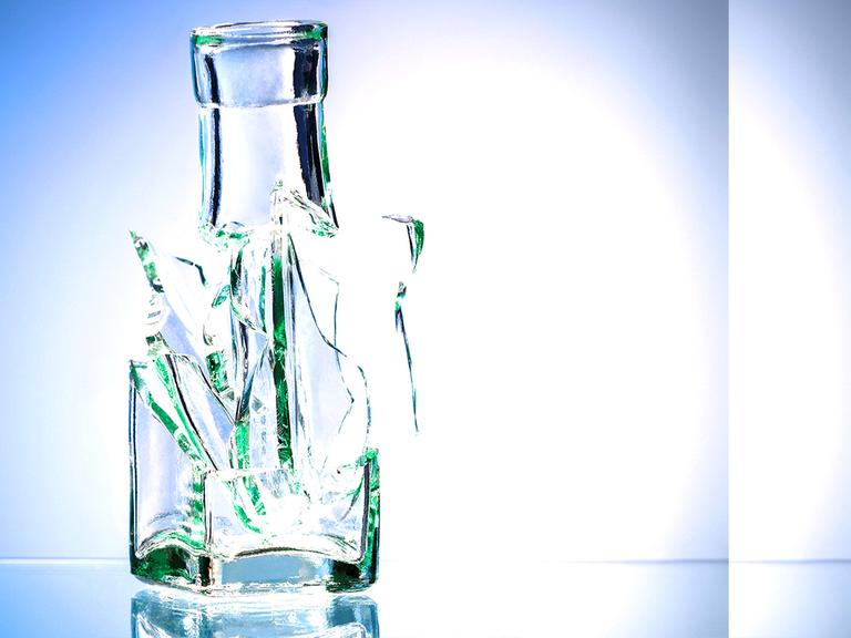 Eine zerbrochene Flasche vor blauem Hintergrund
