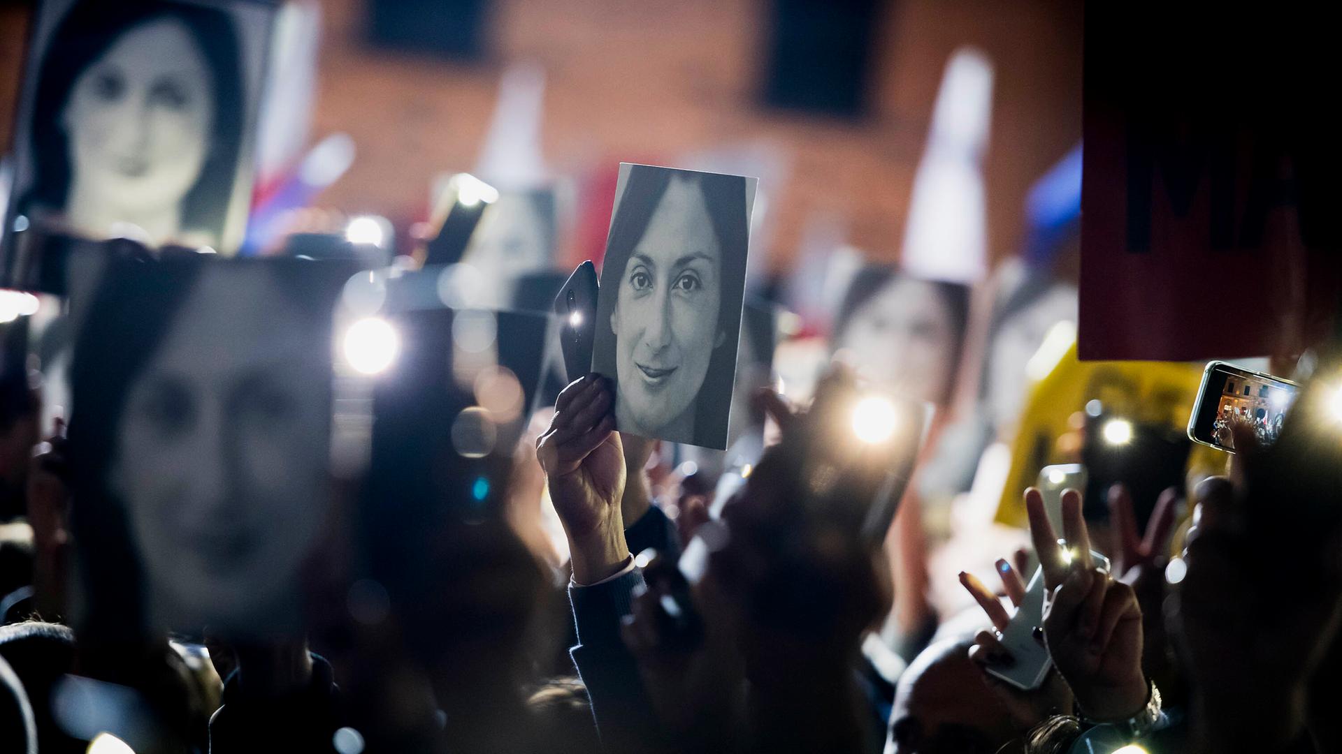 Demonstrierende halten Bilder der ermordeten Journalistin Daphne Caruana Galizia hoch.