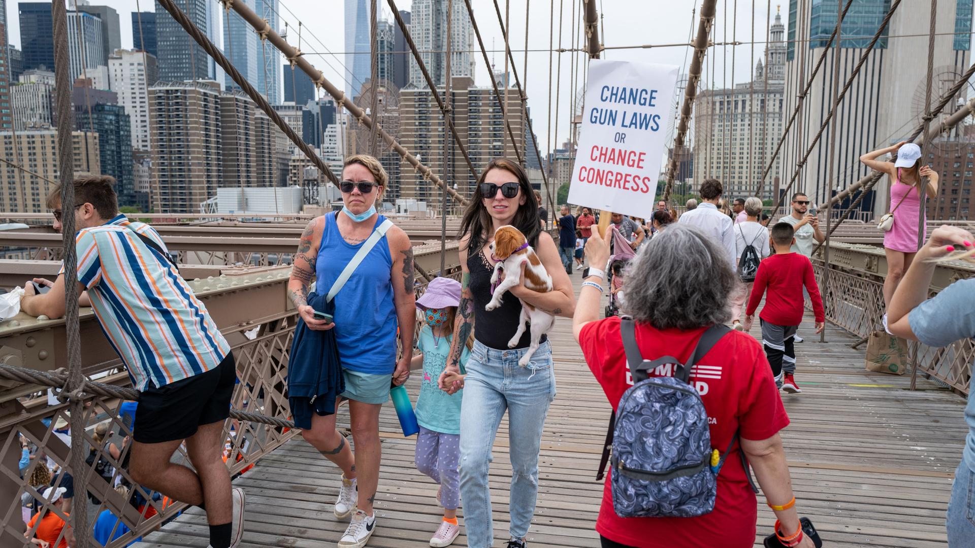 Menschen marschieren über die Brooklyn Bridge, um beim "March for Our Lives" (Marsch für unser Leben) und der Kundgebung am 11. Juni 2022 in New York City gegen Waffengewalt zu protestieren. Auf einem Plakat steht Change Gun Laws or Change Congress. Menschen marschieren über die Brooklyn Bridge, um beim "March for Our Lives" (Marsch für unser Leben) und der Kundgebung am 11. Juni 2022 in New York City gegen Waffengewalt zu protestieren. Auf einem Plakat steht Change Gun Laws or Change Congress.