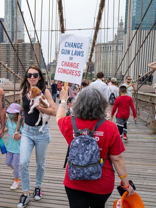 Menschen marschieren über die Brooklyn Bridge, um beim "March for Our Lives" (Marsch für unser Leben) und der Kundgebung am 11. Juni 2022 in New York City gegen Waffengewalt zu protestieren. Auf einem Plakat steht Change Gun Laws or Change Congress.