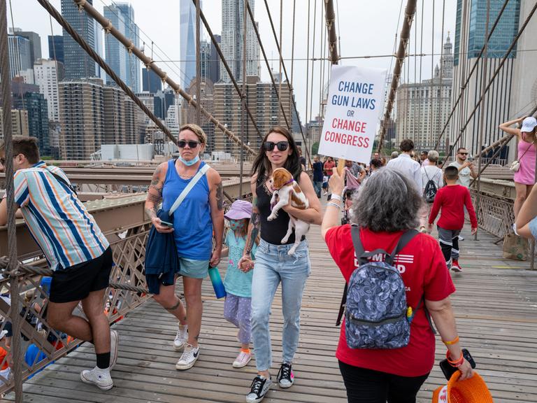 Menschen marschieren über die Brooklyn Bridge, um beim "March for Our Lives" (Marsch für unser Leben) und der Kundgebung am 11. Juni 2022 in New York City gegen Waffengewalt zu protestieren. Auf einem Plakat steht Change Gun Laws or Change Congress.