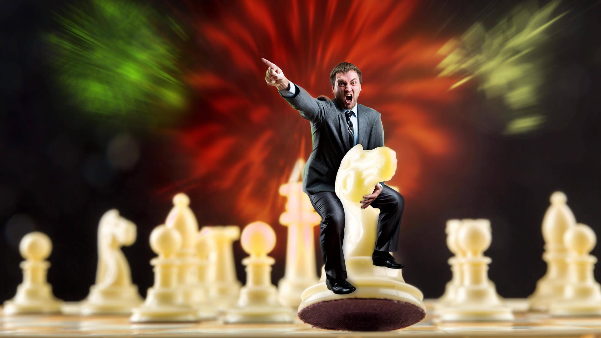 Ein weißer Mann sitzt auf einer weißen Schachfigur auf einem Schachbrett und gibt mit seinem Finger die Richtung vor.