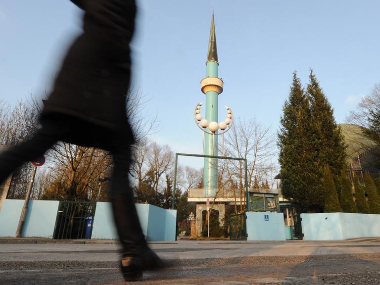 Eine Frau, die nur in ihrem Umrissen zu erkennen ist, geht in München-Freimann am Islamischen Zentrum München vorbei. 
