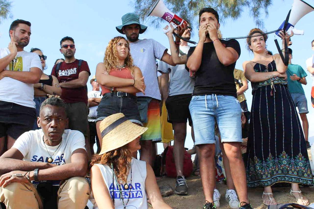 Eine Gruppe von Menschen hat sich zu einer Kundgebung versammelt. Ein junger Mann hält eine Ansprache, verstärkt durch zwei Megaphone. Eine Gruppe von Menschen hat sich zu einer Kundgebung versammelt. Ein junger Mann hält eine Ansprache, verstärkt durch zwei Megaphone.