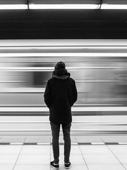 Eine junge Frau wird in der U-bahn belästigt. Als ein Fahrgast eingreift, eskaliert die Situation. Zu sehen: Eine Person steht mit dem Rücken zur Kamera auf einem U-Bahnhof.
