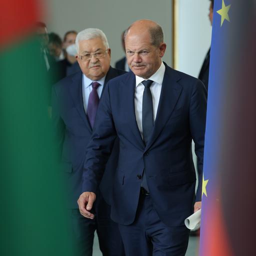 Mahmoud Abbas (L), Präsident der Palästinensischen Autonomiebehörde, und Bundeskanzler Olaf Scholz eingerahmt zwischen den offiziellen Flaggen während der Pressekonferenz.