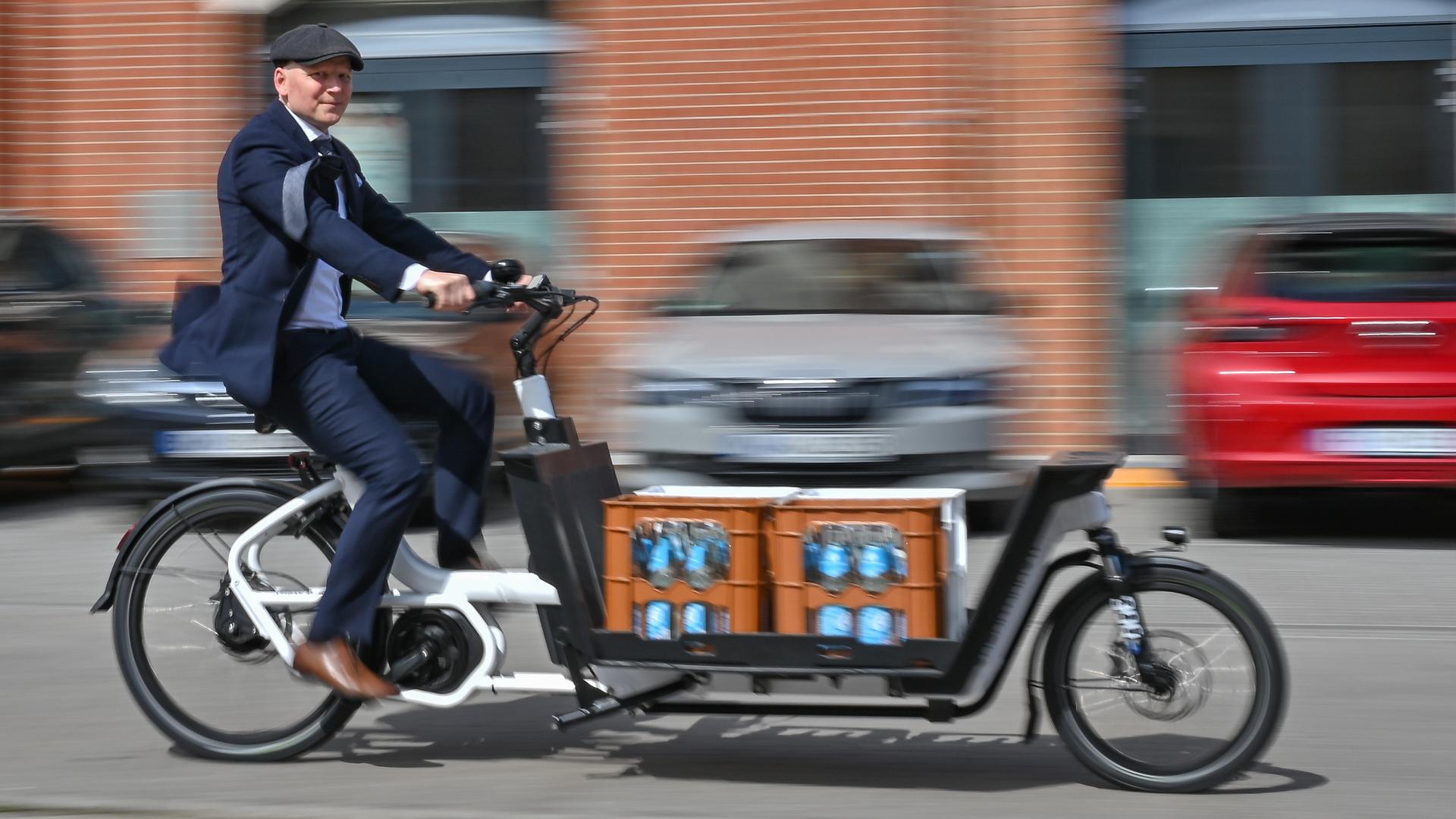 Stefan Döbrich, Geschäftsführer Business auf Rädern GmbH, fährt mit einem Lastenfahrrad über eine Straße