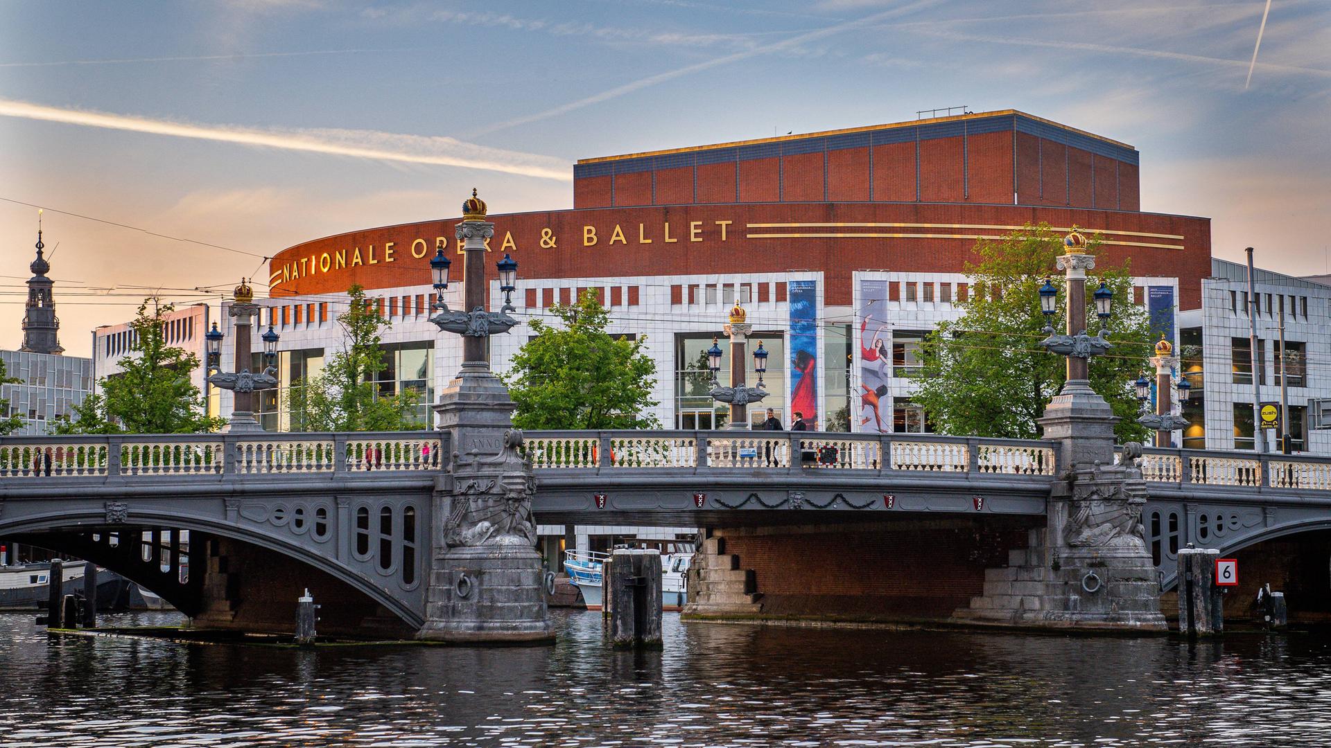 Außenaufnahme des Opernhauses in Amsterdam. Davor eine Brücke und eine Gracht. Dahinter Abendhimmel. Außenaufnahme des Opernhauses in Amsterdam. Davor eine Brücke und eine Gracht. Dahinter Abendhimmel.