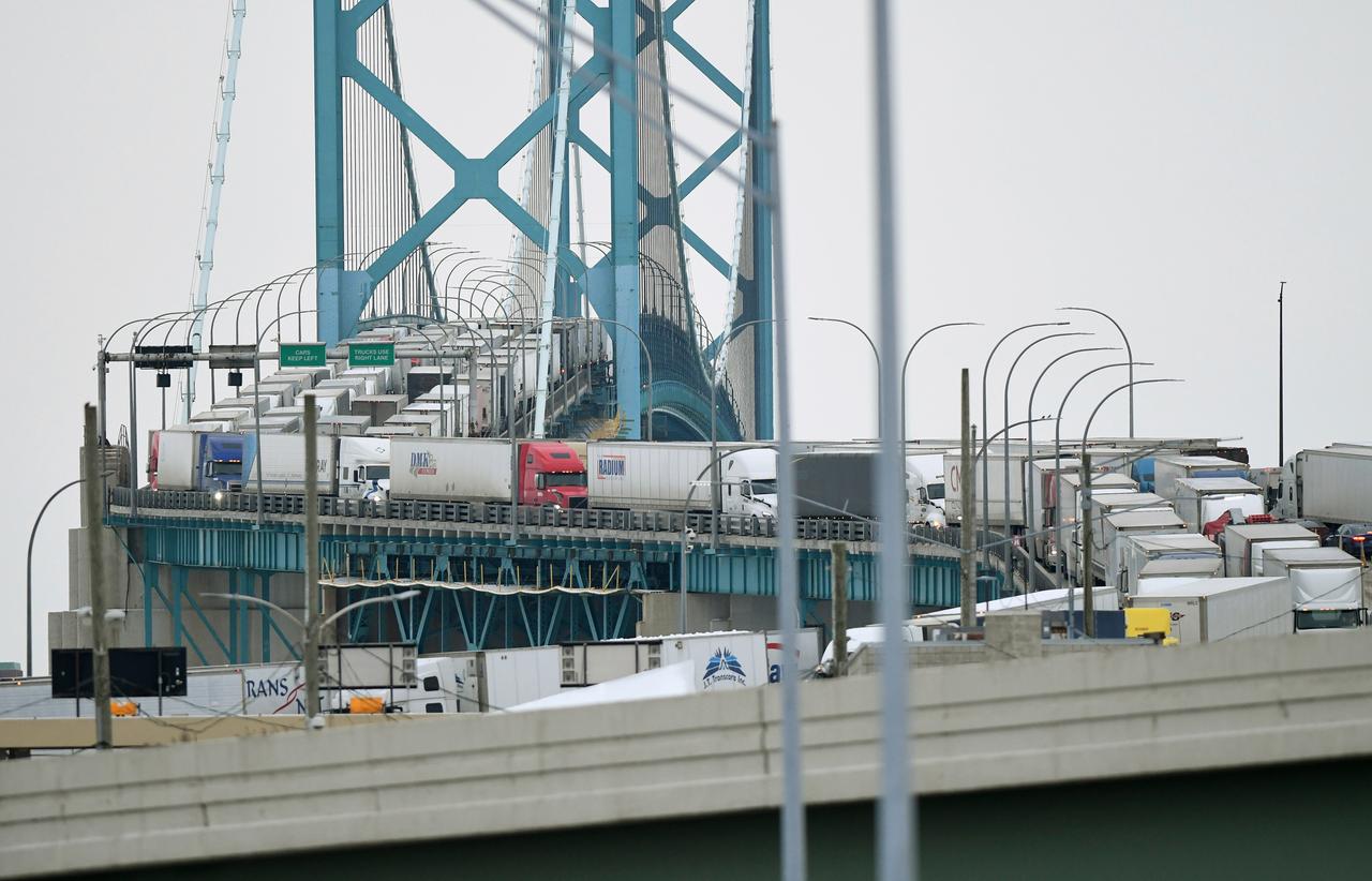 Das Foto zeigt Trucker und andere Autofahrer, die eine Brücke blockieren.
