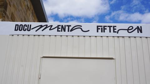 Auf einem Container vor dem Documentagelände in Kassel prangt die Aufschrift "Documenta Fifteen". Die Fenster des Containers sind geschlossen.