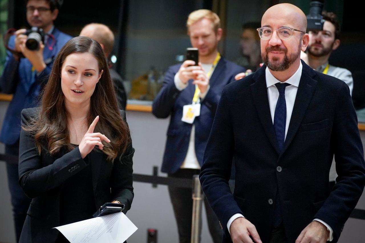 Sanna Marin und Charles Michel. Eine Frau und ein Mann stehen mit anderen Personen in einem Sitzungssaal, während sie fotografiert werden. Sanna Marin und Charles Michel. Eine Frau und ein Mann stehen mit anderen Personen in einem Sitzungssaal, während sie fotografiert werden.