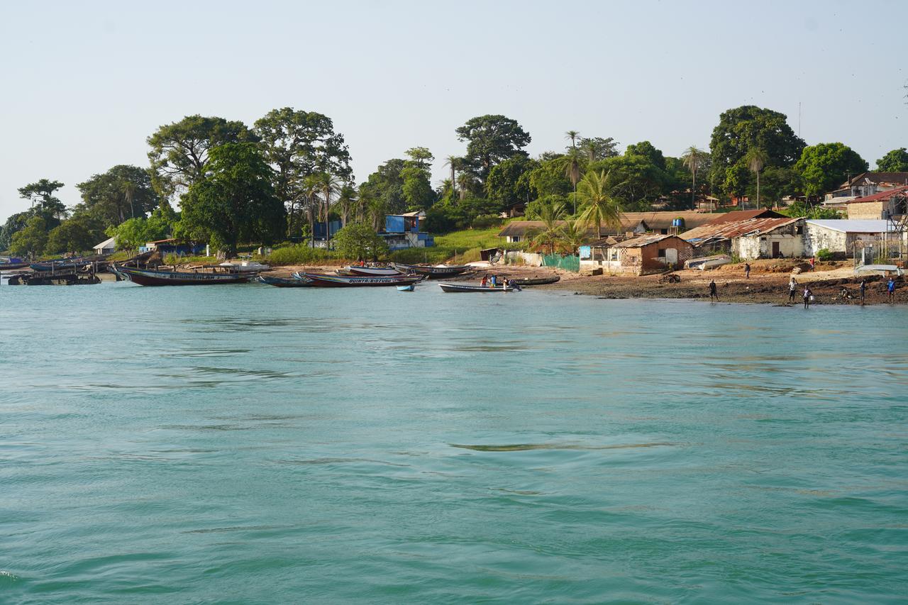 Vom Wasser aus sieht man die Insel Bubaque mit dem Strand und einigen Häusern. Vom Wasser aus sieht man die Insel Bubaque mit dem Strand und einigen Häusern.