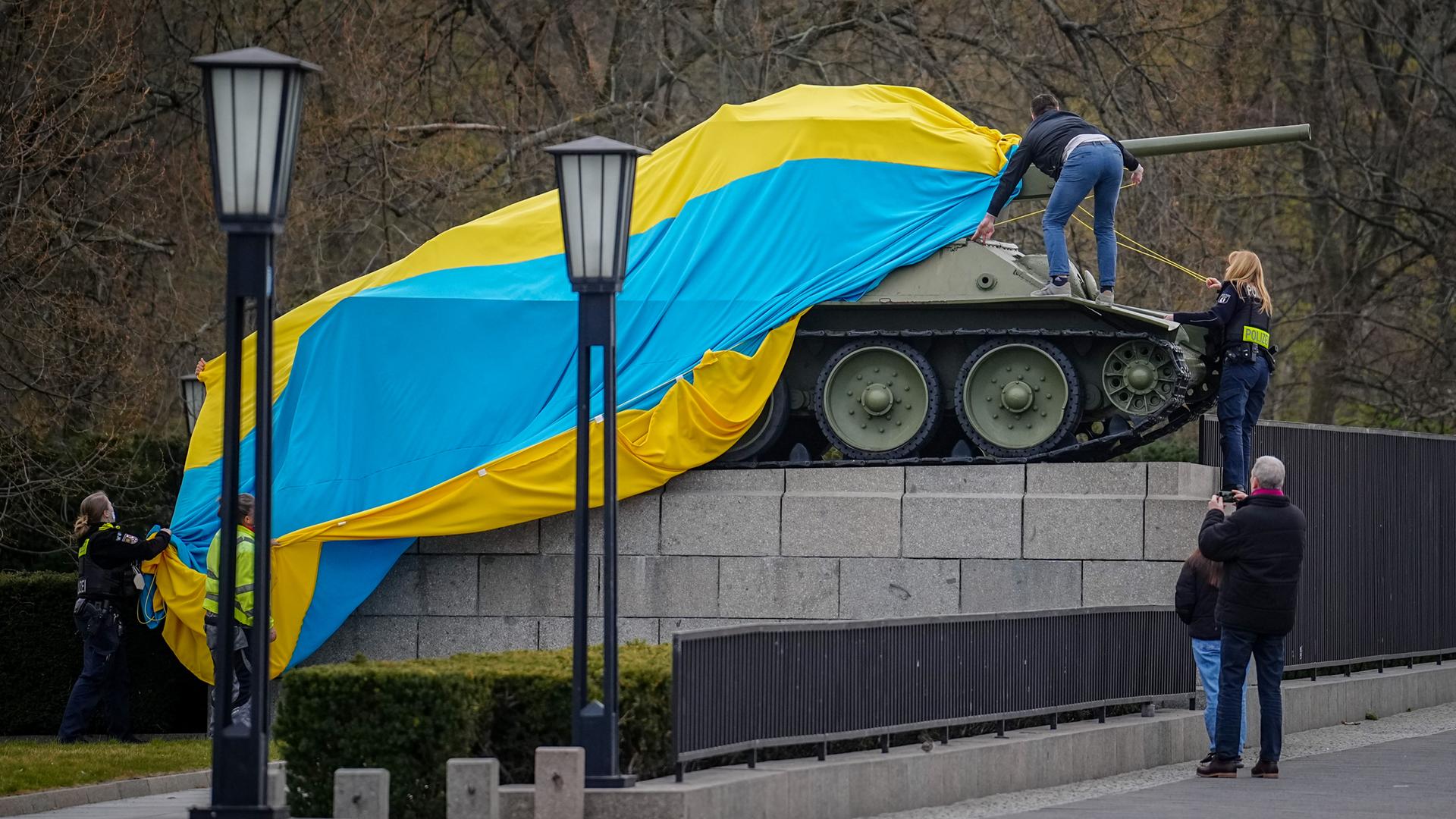 Polizeibeamte entfernen die Flagge der Ukraine von einem historischen Panzer am Sowjetischen Ehrenmal an der Straße des 17. Juni in Berlin.