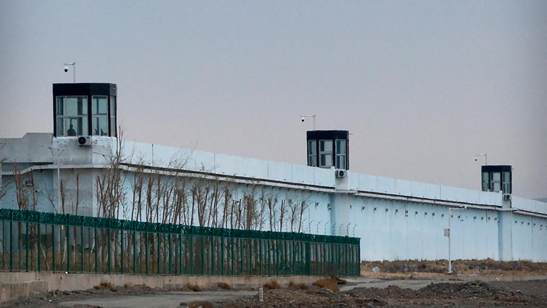 Eine Person steht in einem Turm am Rande des Internierungslagers Nr. 3 in Dabancheng.