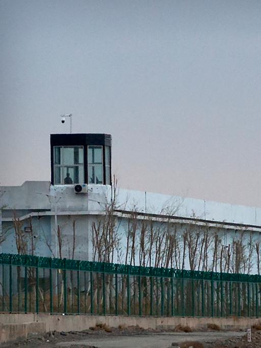 Eine Person steht in einem Turm am Rande des Internierungslagers Nr. 3 in Dabancheng.