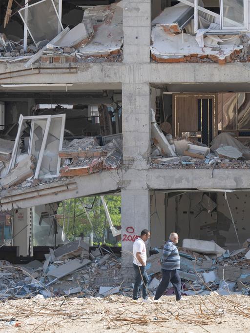 Anwohner gehen an einer zerstörten Häuserzeile entlang. Weite Teile der Stadt wurden bei dem Erdbeben vom sechsten Februar komplett zerstört.