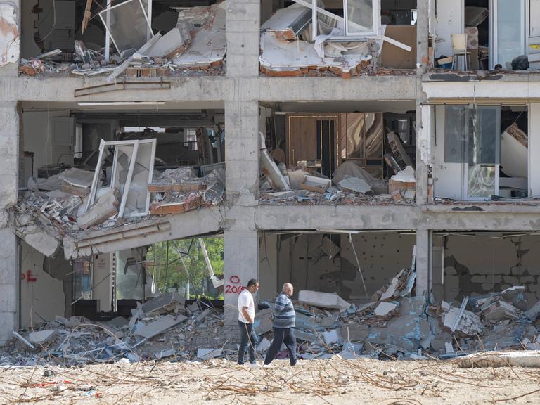 Anwohner gehen an einer zerstörten Häuserzeile entlang. Weite Teile der Stadt wurden bei dem Erdbeben vom sechsten Februar komplett zerstört.