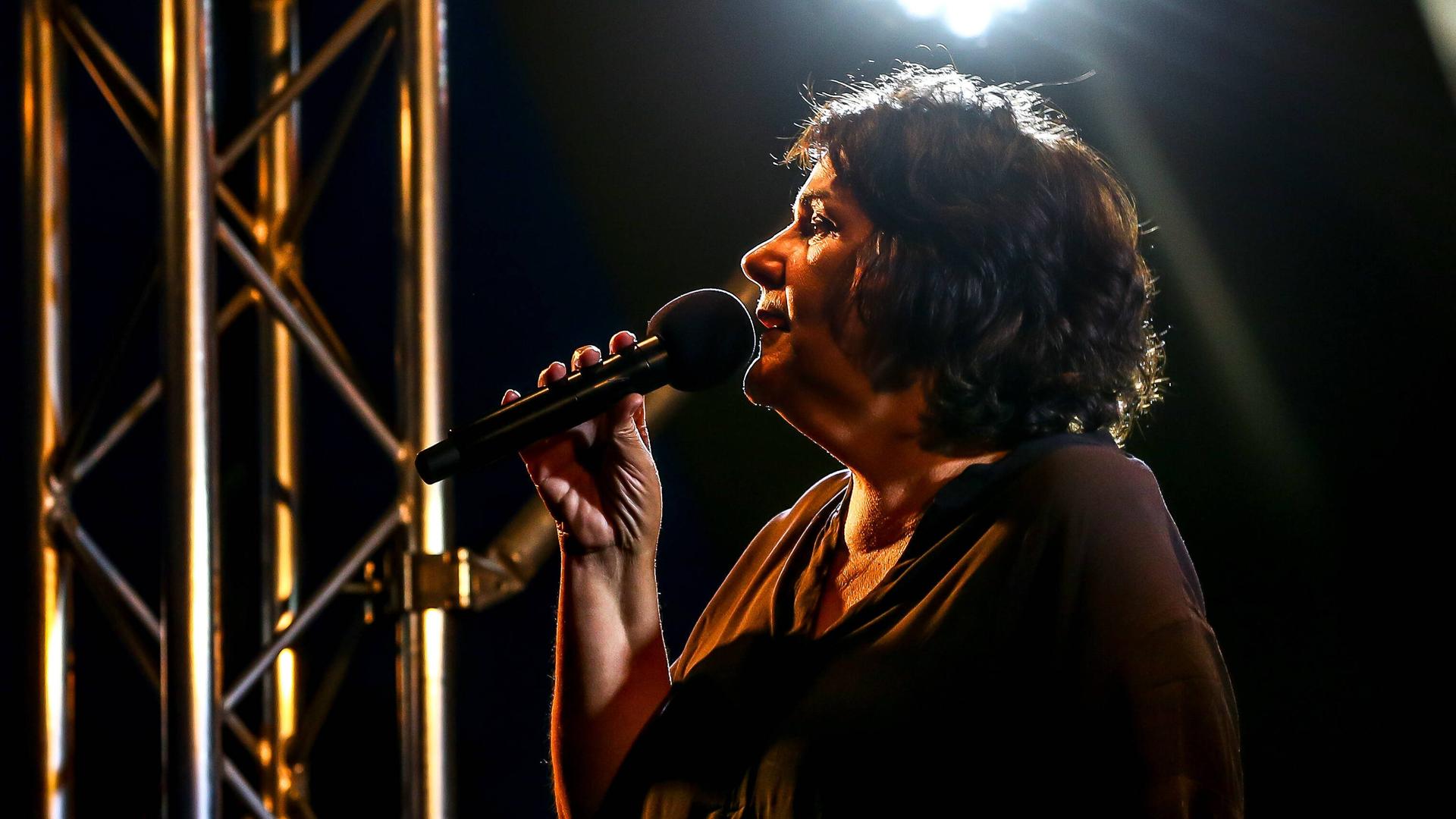 Christiane Rösinger singt auf einer Bühne. Christiane Rösinger singt auf einer Bühne.
