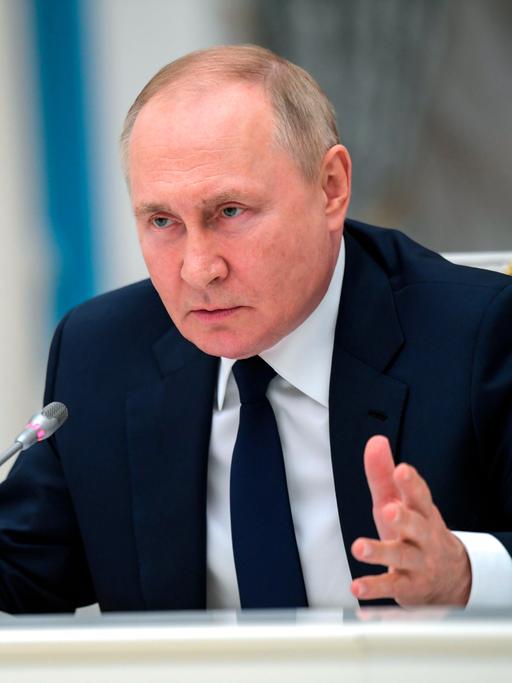 Russlands Präsident Wladimir Putin spricht in ein Mikrofon.