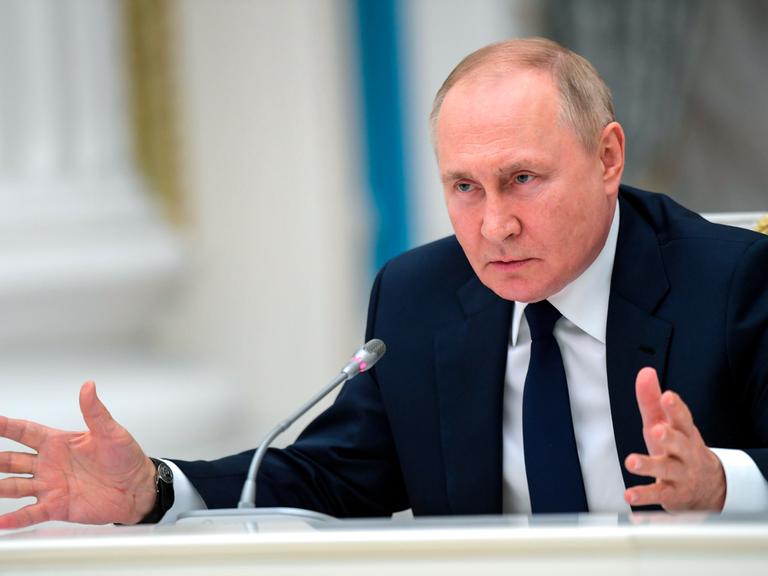 Russlands Präsident Wladimir Putin spricht in ein Mikrofon.