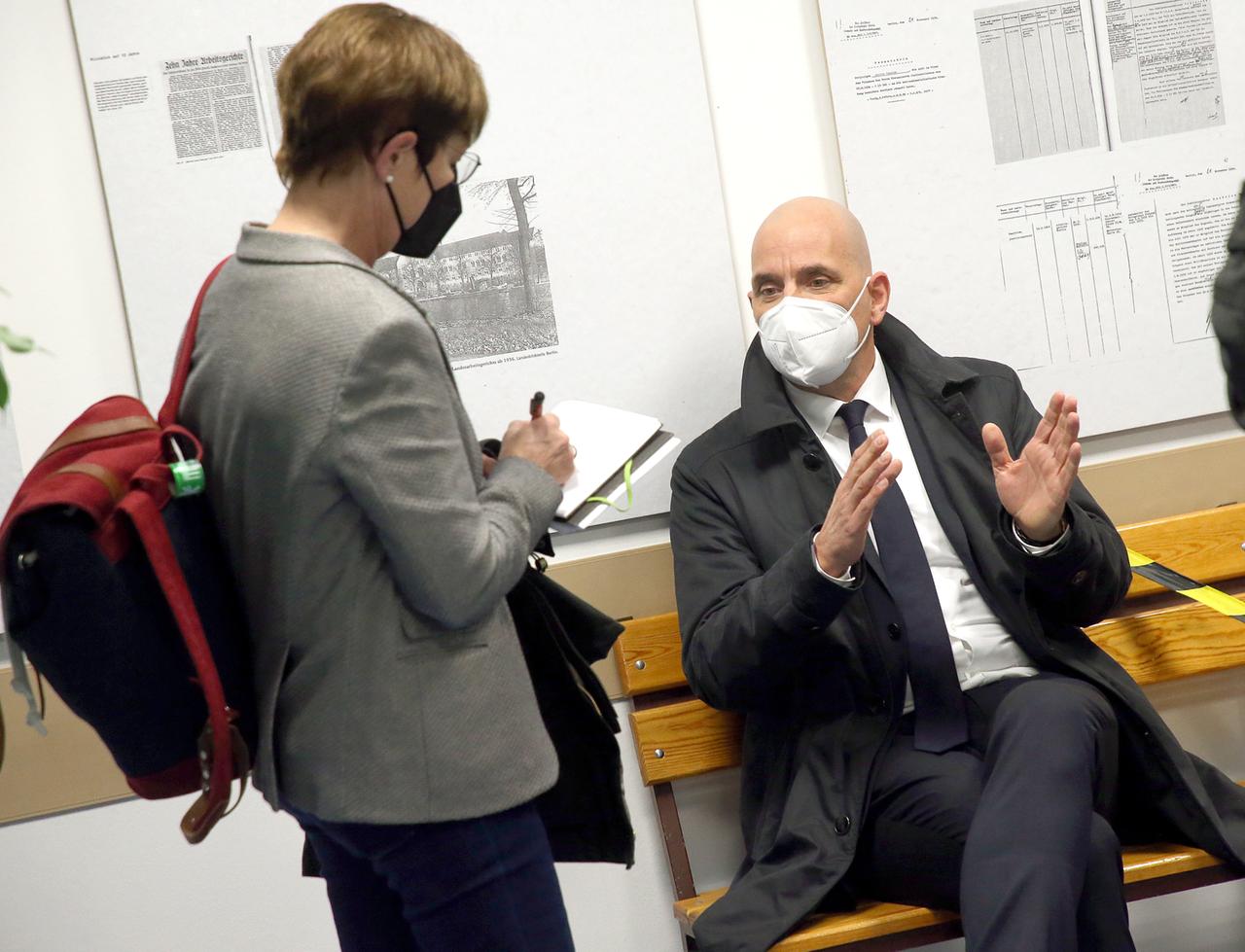 Eine Journalistin unterhält sich im Arbeitsgericht Berlin mit Rechtsanwalt Martin Bechert.