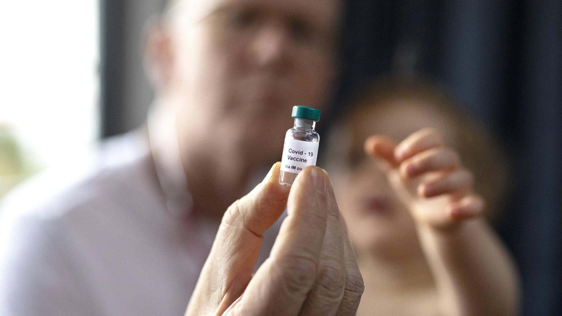 Ein Kinderarzt hält Impfstoff in der Hand. Ein Kinderarzt hält Impfstoff in der Hand.