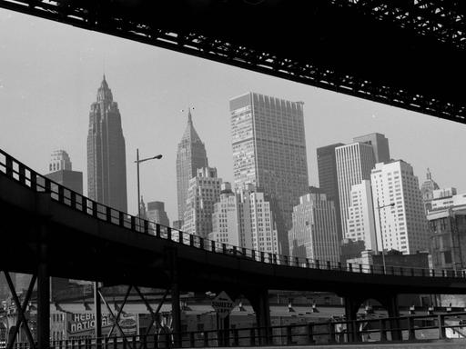 Ein schwarz weiß Foto von New York, in den USA, um 1959. Der Blick geht durch zwei Brücken auf Hochkratzer.