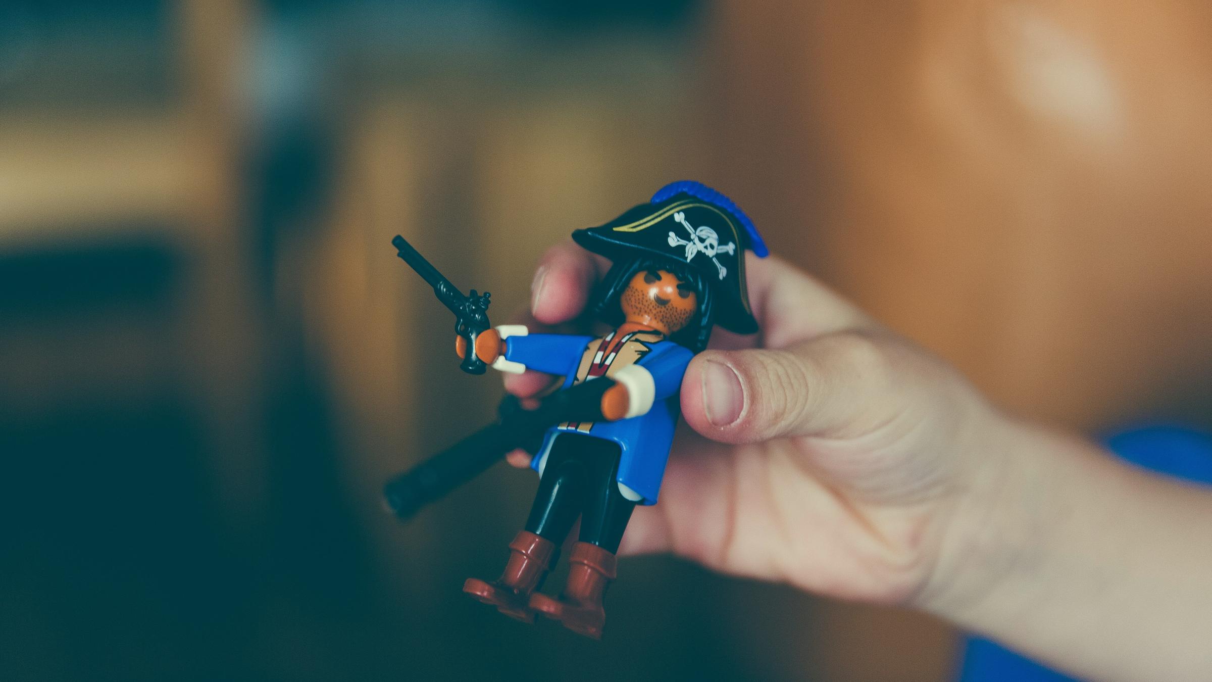 Eine Hand hält ein Playmobil-Piratenmännchen.