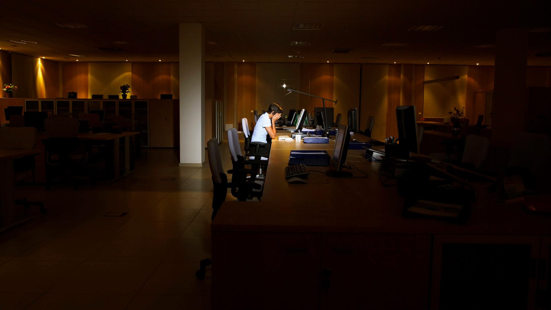 Müde einsame Person vor einem Bürorechner. Müde einsame Person vor einem Bürorechner.