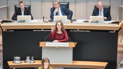 Maja Lasić vor einigen Jahren bei der Aktuellen Stunde zur Schulsanierung im Berliner Abgeordnetenhaus, mittlerweile arbeitet Lasić als Lehrerin. Sie steht an einem Rednerpult und gestikuliert, im Hintergrund sind Herren an Rechnern zu sehen. 