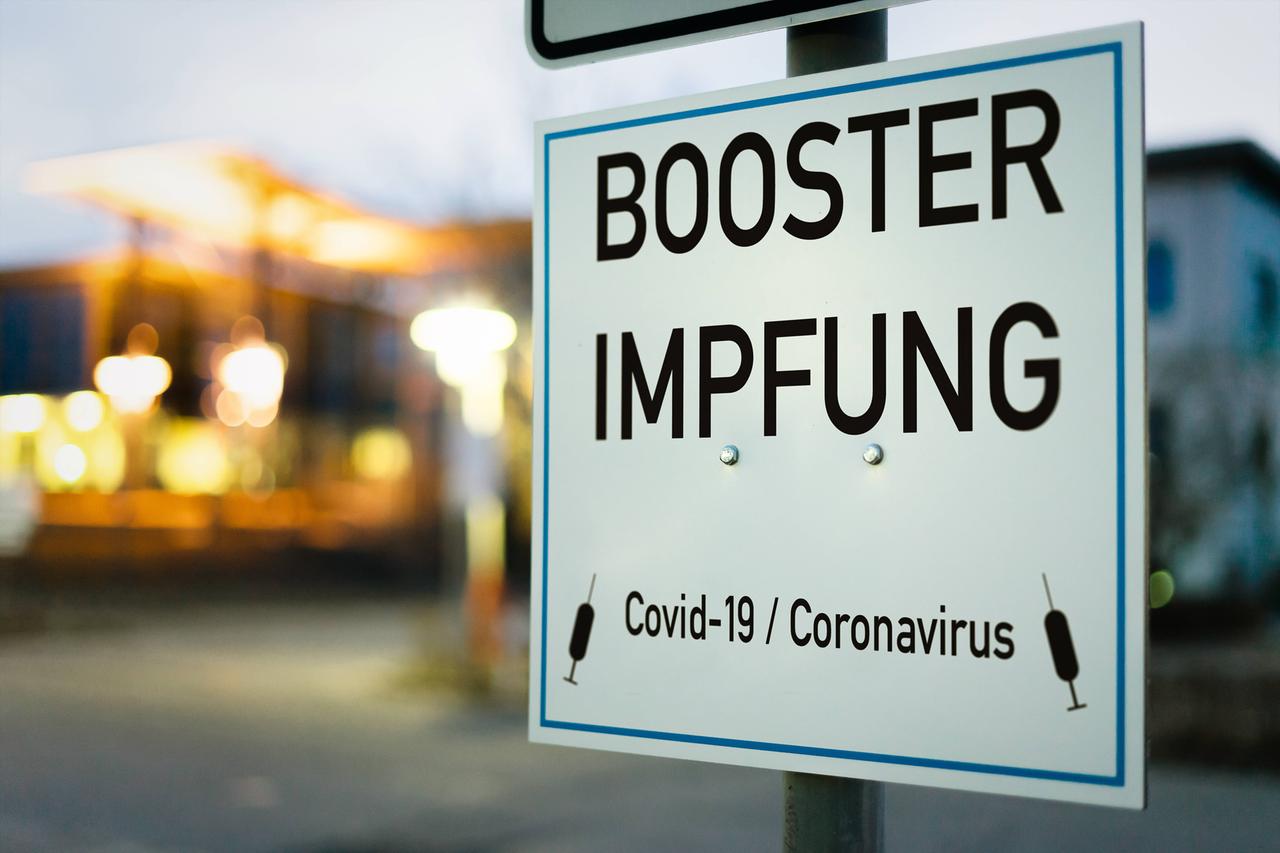 Schild mit der Aufschrift "Booster-Impfung" Schild mit der Aufschrift "Booster-Impfung"