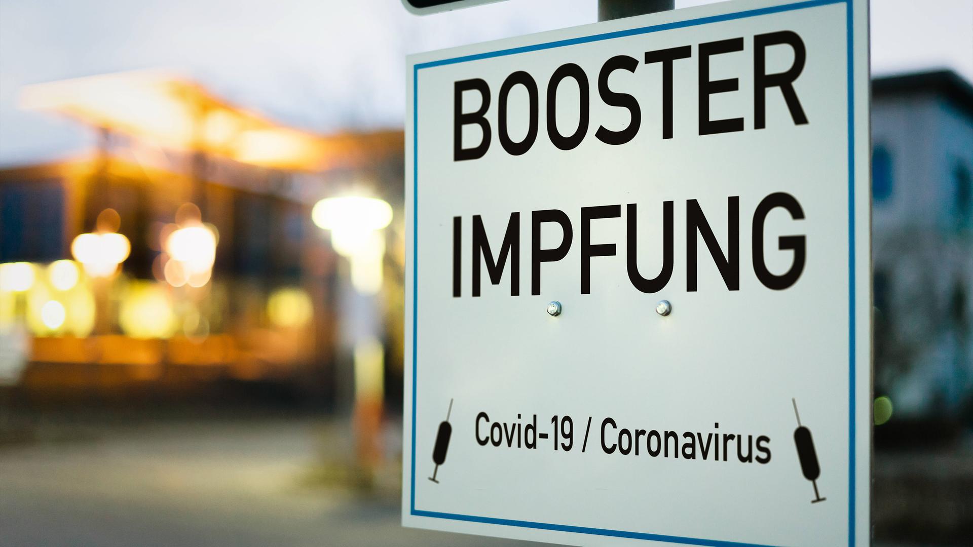 Schild mit der Aufschrift "Booster-Impfung" Schild mit der Aufschrift "Booster-Impfung"