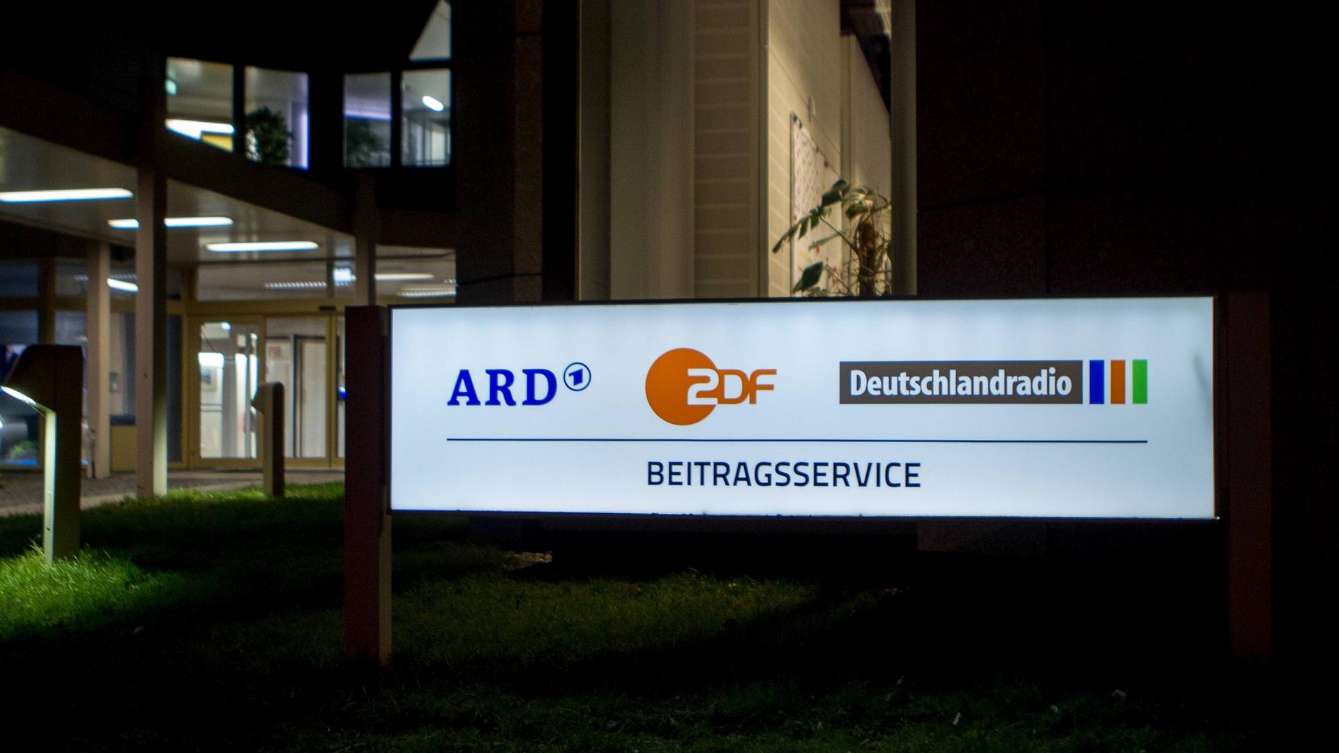 Ein Schild mit dem Schriftzug Beitragsservice vor einem WDR-Gebäude.