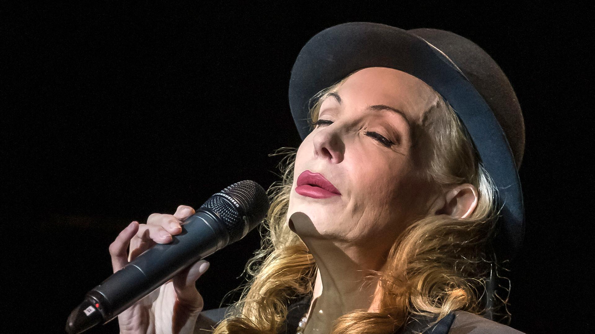 Ute Lemper singt in ein Mikrofon. Ute Lemper singt in ein Mikrofon.