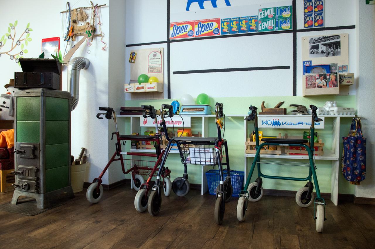 Drei Rollatoren stehen vor einem Regal mit Produkten der ehemaligen DDR: Auf Bildern an der Wand sind die Marken "Spee", "Gemol" und "IMI" zu erkennen. Drei Rollatoren stehen vor einem Regal mit Produkten der ehemaligen DDR: Auf Bildern an der Wand sind die Marken "Spee", "Gemol" und "IMI" zu erkennen.