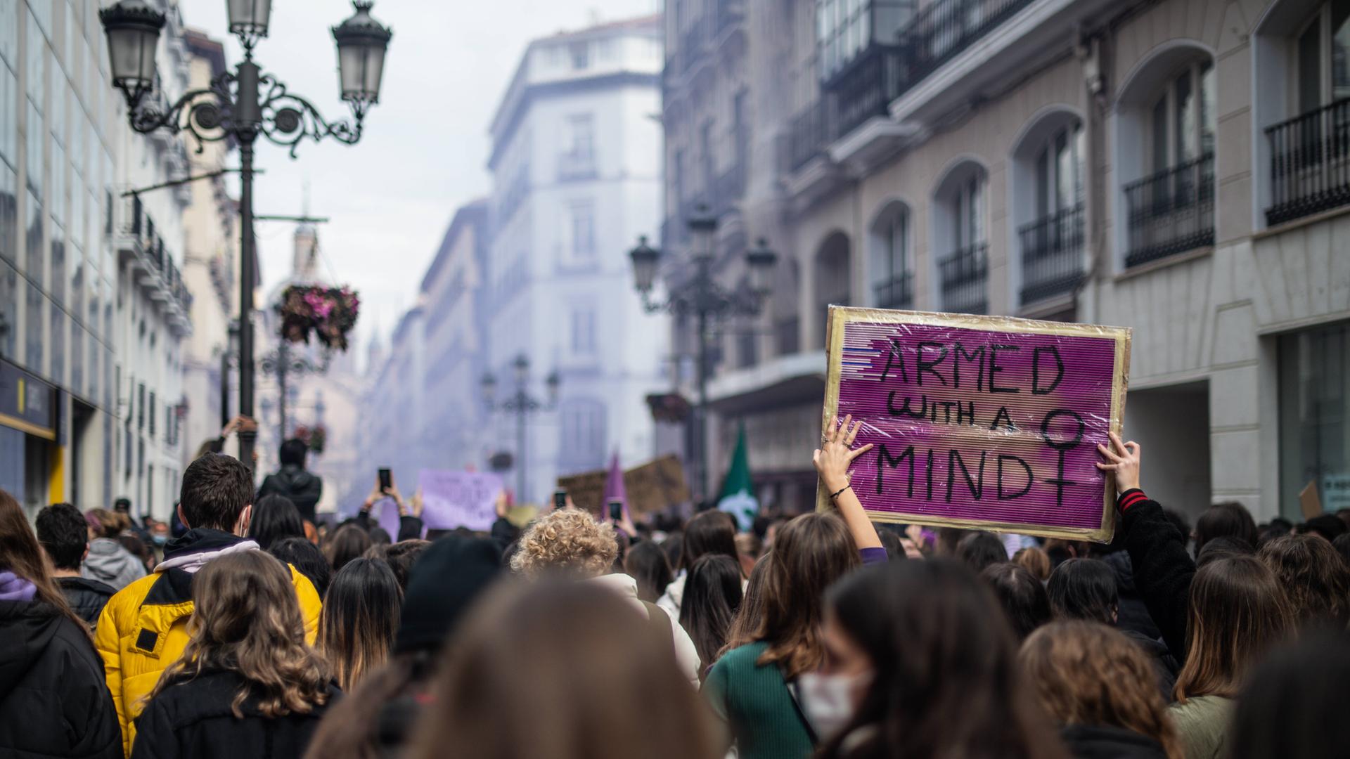 Bei einer feministischen Demonstration ist ein Plakat mit der Aufschrift "Armed With A Mind" zu sehen. Bei einer feministischen Demonstration ist ein Plakat mit der Aufschrift "Armed With A Mind" zu sehen.