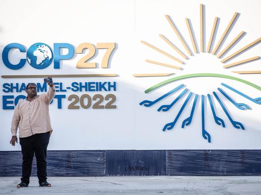 Ein Mann macht ein Selfie mit dem Logo der UNO-Klimakonferenz COP27 im International Convention Center im ägyptischen Badeort Scharm el Scheich.