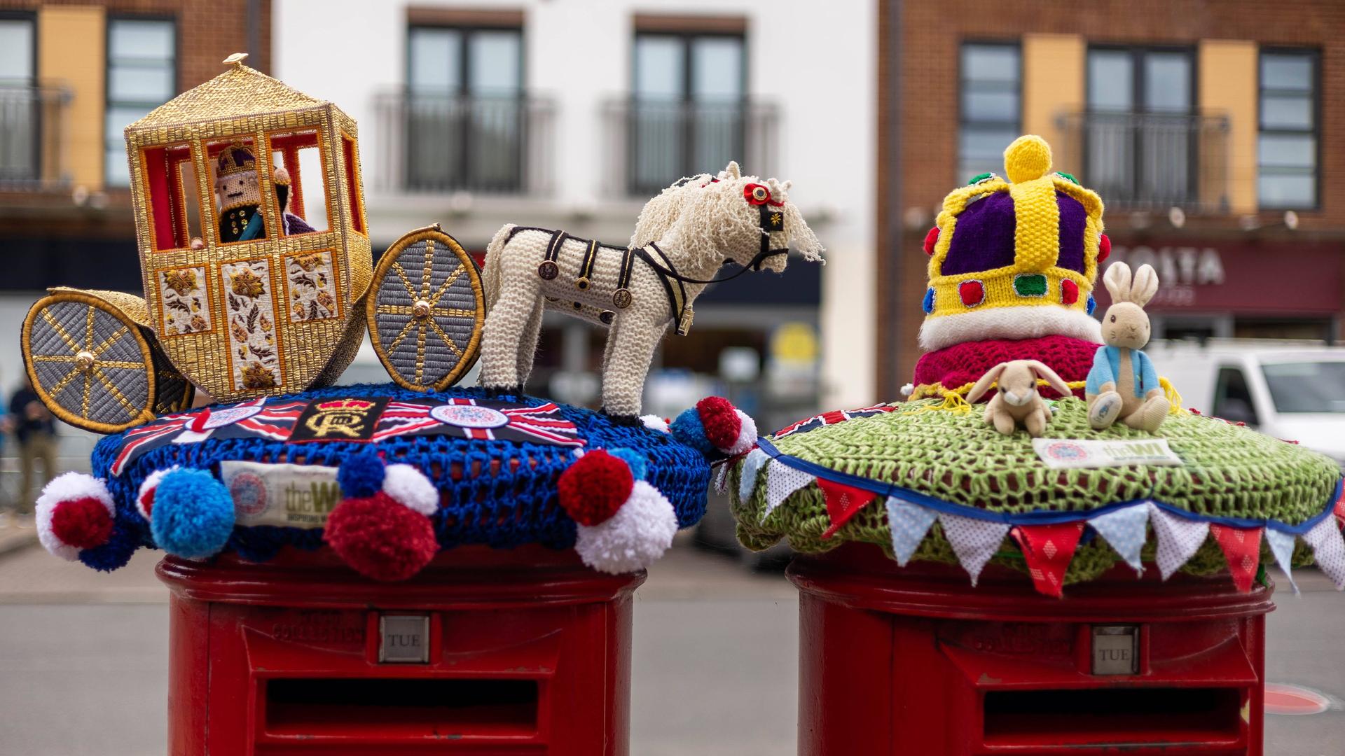 Bunt gestrickte Figuren einer Königskutsche schmücken Briefkästen. Bunt gestrickte Figuren einer Königskutsche schmücken Briefkästen.