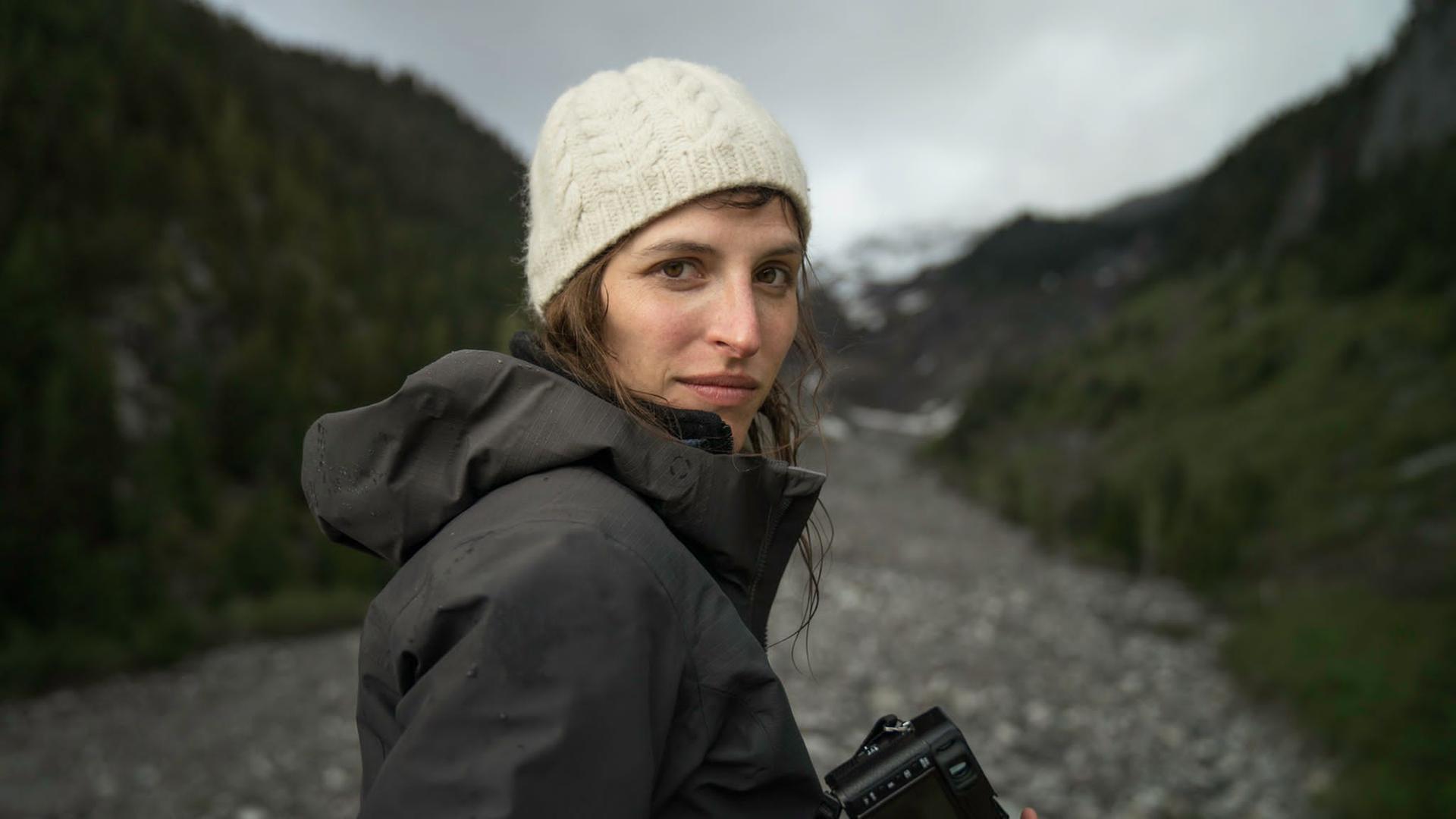 Porträt der Journalistin und Aktivistin Theresa Breuer in der Natur in Regenjacke mit Kamera in der Hand. Porträt der Journalistin und Aktivistin Theresa Breuer in der Natur in Regenjacke mit Kamera in der Hand.